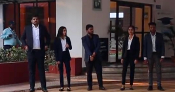 Students in formal attire standing near campus entrance at KIM Harihar