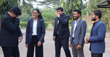 Students in formal attire interacting and networking outdoors on campus at Kirloskar Institute of Management