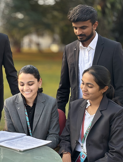 Students in formal attire reviewing documents together on campus at Kirloskar Institute of Management