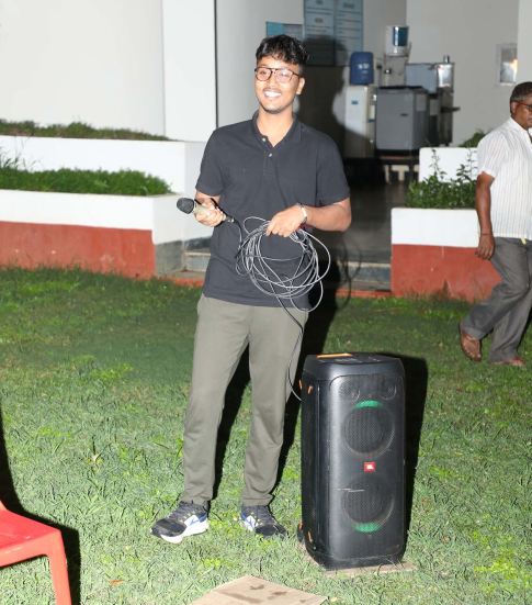 Student standing at the KIM campus with speaker and microphone enjoying during an event
