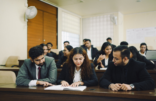 Students in formal attire studying and discussing together during a classroom session